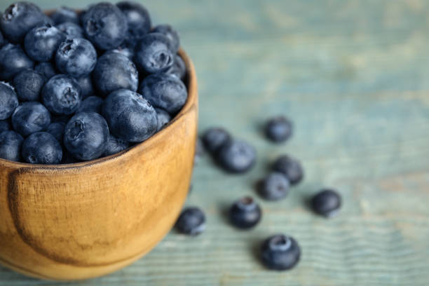 istock Fresh ripe blueberries in bowl on wooden table, closeup. Space for text 1348861354