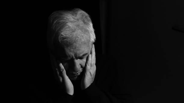 istock Depressed elderly man alone in the dark 1348861656