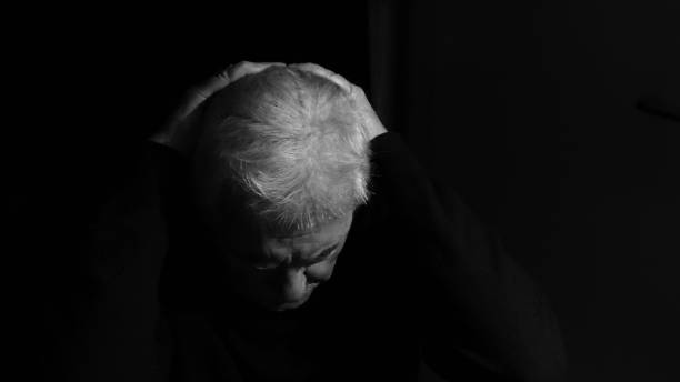 istock Depressed elderly man alone in the dark 1348861661