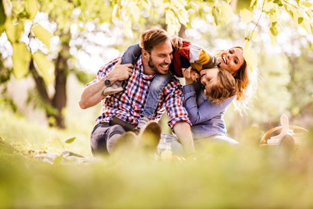istock Playful family having fun on picnic at the park. 1348861663