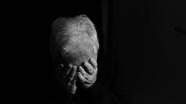 istock Depressed elderly man alone in the dark 1348861674