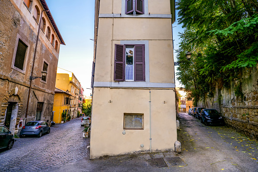 A characteristic corner with two alleys in the ancient Trastevere district, in the historic heart of the Eternal City. Trastevere is an iconic district of the Eternal City, due to the presence of countless artistic and historical treasures, monuments and ancient Romanesque and Baroque churches, but also for its squares and alleys to be explored freely, where it is easy to find typical restaurants, pubs, small shops of artisans and scenes of daily life with the original Roman soul. In 1980 the historic center of Rome was declared a World Heritage Site by Unesco. Super wide angle and high definition image.