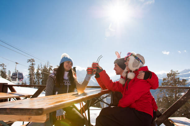 grupo de amigos disfrutando de vino caliente caliente en la cafetería de la estación de esquí. - skiing snow couple mountain fotografías e imágenes de stock