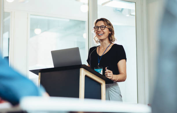 female business professional addressing a seminar - presentatie stockfoto's en -beelden