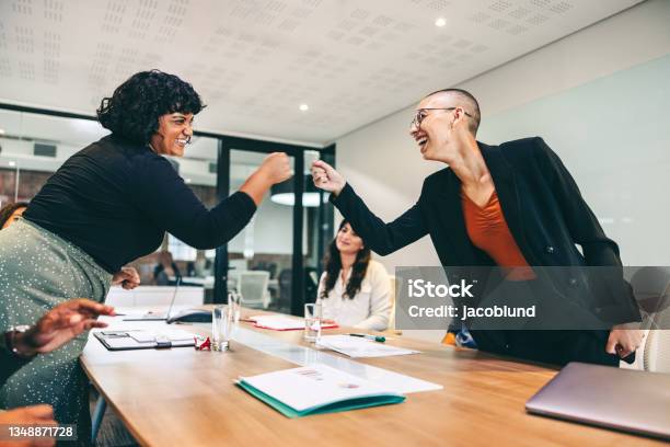 Cheery Businesswomen Fist Bumping Each Other Before A Meeting Stock Photo - Download Image Now