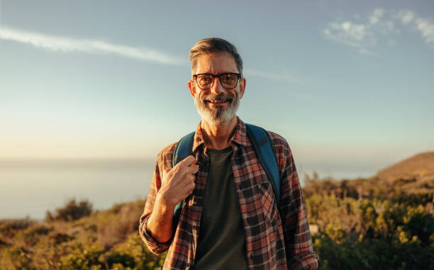 istock Mature hiker smiling at the camera while standing outdoors 1348872557