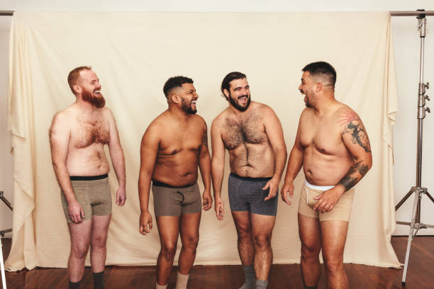 czterech mężczyzn bez koszuli śmiejących się radośnie w studiu - chest hair zdjęcia i obrazy z banku zdjęć