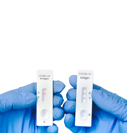 The doctor compares tape from a rapid antigen test kit for a covid-19 result, vertical copy space on white background