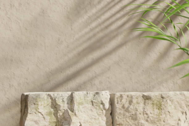 istock Three mockup boulders against a beige stone wall. Stage for product presentation. Shallow depth of field. 3D render. 1348874045