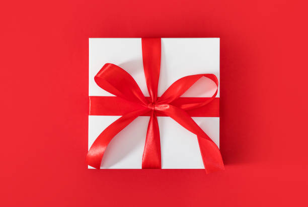 istock gift box on red background with red bow with place for text 1348876140