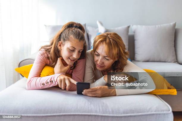 Mother And Daughter Using A Smartphone Stock Photo - Download Image Now - Teenager, Parent, Child