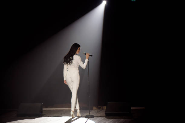 istock Singer on stage in a beam of white light. 1348883432