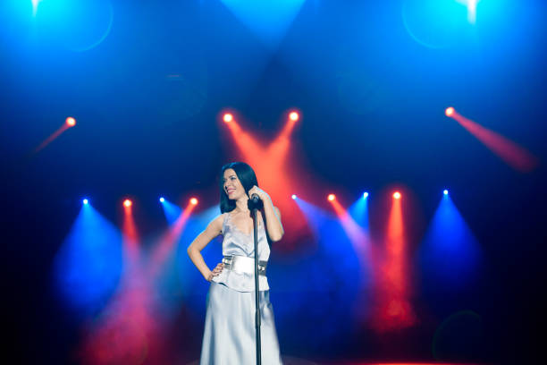 istock Bright stage lighting. Vocalist singing to microphone. 1348884970