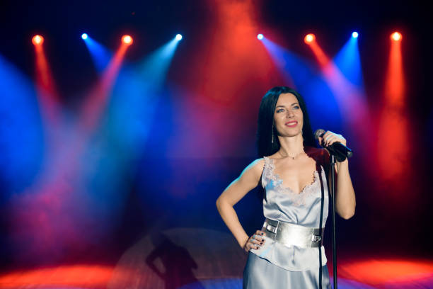 istock Bright stage lighting. Vocalist singing to microphone. 1348884985