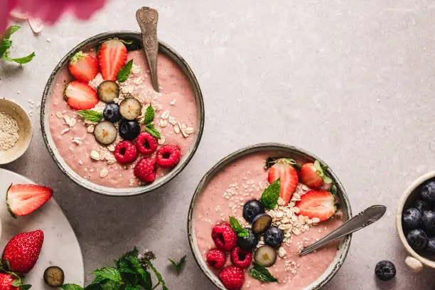 Close-up of freshly made strawberry smoothie bowls on the kitchen counter. Delicious fruit smoothie bowls on kitchen table,