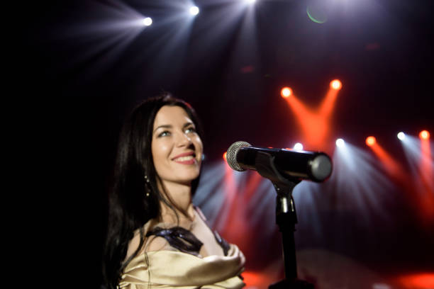 istock Young woman with microphone in hand on entertainment event. 1348886254