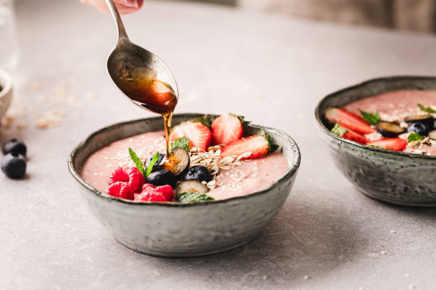 Pouring honey over smoothie bowl
