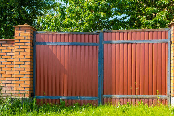 istock Black metal gates with brick pillars. summer day 1348886530