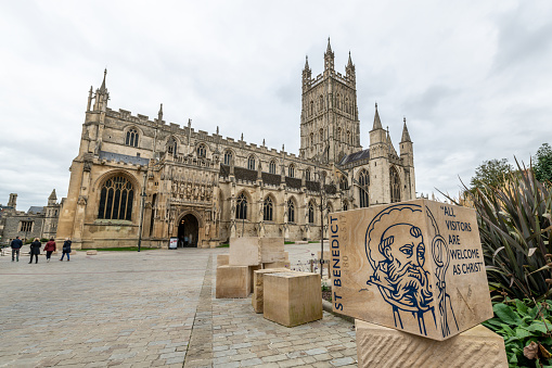 Sandstone signs with welcome writing and images welcome visitors to Gloucester Cathedral