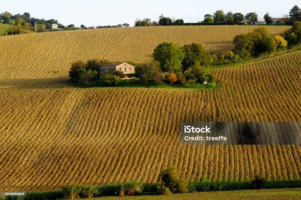 Small farmhouse in the middle of plowed fields Agricolture in Marche. Farmhouse in autumn Marche - Italy Stock Photo