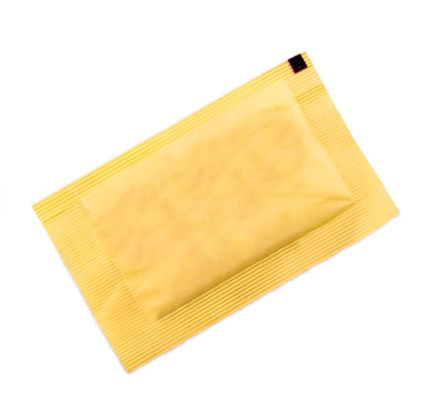 piccolo sacchetto di carta gialla con zucchero per caffè su fondo bianco - sugar sachet foto e immagini stock