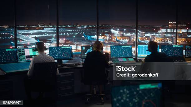 Diverse Air Traffic Control Team Working In A Modern Airport Tower At Night Office Room Is Full Of Desktop Computer Displays With Navigation Screens Airplane Flight Radar Data For Controllers Stock Photo - Download Image Now