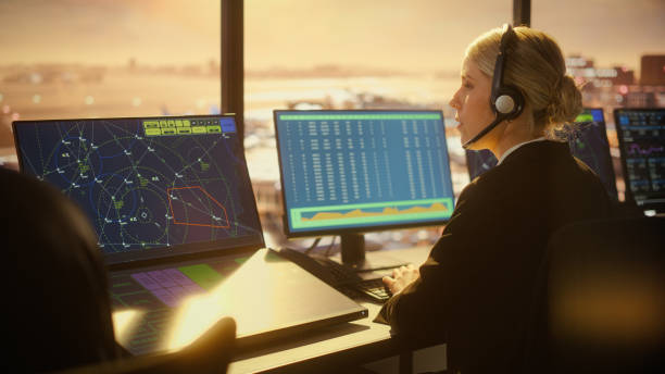 Female Air Traffic Controller with Headsets Talk in Airport Tower. Office Room Full of Desktop Computer Displays with Navigation Screens, Airplane Flight Radar Data for Controllers. Female Air Traffic Controller with Headsets Talk in Airport Tower. Office Room Full of Desktop Computer Displays with Navigation Screens, Airplane Flight Radar Data for Controllers. atc stock pictures, royalty-free photos & images