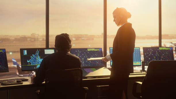 istock Diverse Air Traffic Control Team Working in Modern Airport Tower at Sunset. Controllers Celebrate the First Take Off of a New Commercial Aircraft with Clapping Hands in a Room Full of Computers. 1348905571