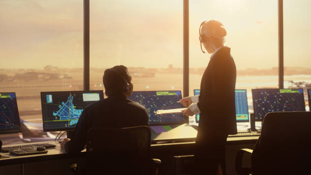 diverse air traffic control team working in modern airport tower at sunset. controllers celebrate the first take off of a new commercial aircraft with clapping hands in a room full of computers. - color image people air vehicle airplane imagens e fotografias de stock