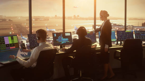 Diverse Air Traffic Control Team Working in a Modern Airport Tower at Sunset. Office Room is Full of Desktop Computer Displays with Navigation Screens, Airplane Flight Radar Data for Controllers. Diverse Air Traffic Control Team Working in a Modern Airport Tower at Sunset. Office Room is Full of Desktop Computer Displays with Navigation Screens, Airplane Flight Radar Data for Controllers. air traffic control operator stock pictures, royalty-free photos & images