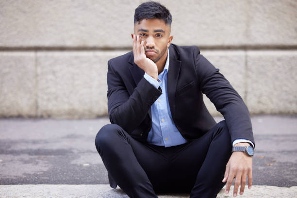 foto de un apuesto joven hombre de negocios sentado y aburrido en la ciudad - quit scene fotografías e imágenes de stock