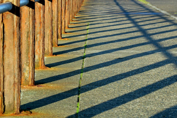 istock Shadows of Rusting Safety Handrail at a Coastal Jetty Location 1348906527