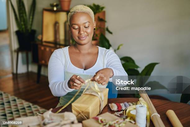 Smiling Young Woman Wrapping Christmas Presents With Recycled Paper Stock Photo - Download Image Now
