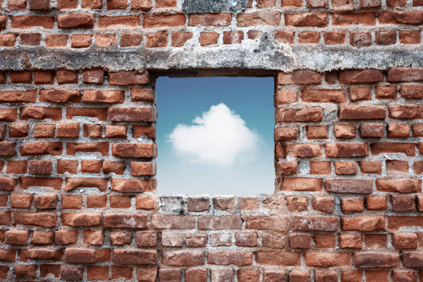 istock Ruined old brick wall window with sky and cloud view. Freedom, dream, imagination or isolation 1348916560