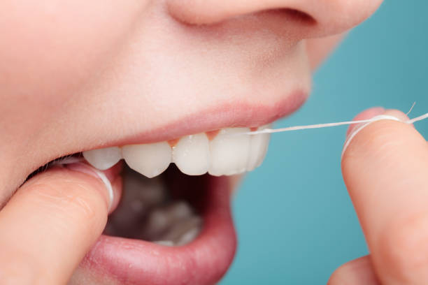 istock side view woman face smiling with dental floss. 1348923475