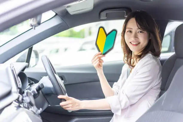 A young female driver with a beginner's mark