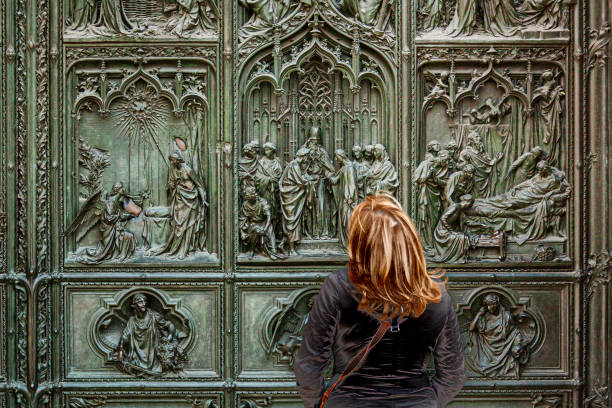 frau, die die details der gotischen fassade des doms betrachtet. - statue angel marble white stock-fotos und bilder