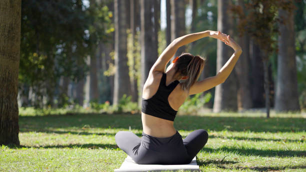 istock Young woman practicing yoga in a public park 1348936916