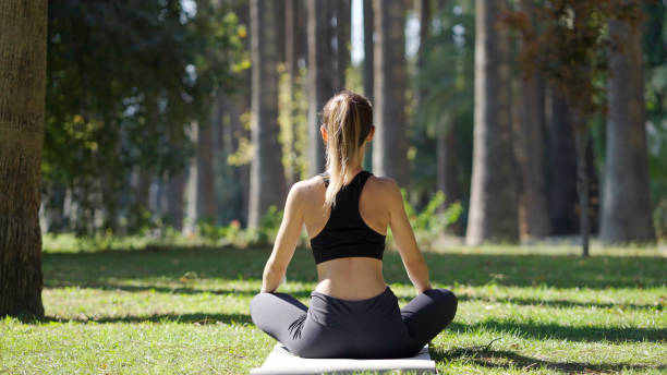 istock Young woman practicing yoga in a public park 1348936918