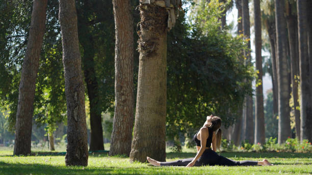 istock Young woman practicing yoga in a public park 1348936967