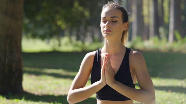 istock Young woman meditating in a public park 1348936981