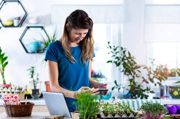 istock Young woman with hearing aid planting micro plants in biodegradable packaging. 1348937628