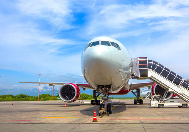 istock Airplane with a passenger boarding steps on the airport apron 1348937986
