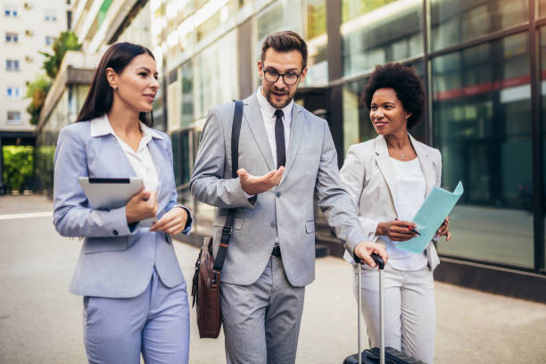 istock Three young business people talking to each other while walking outdoors. 1348938151