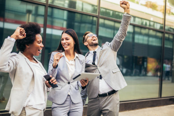 istock Business team celebrating a triumph, looking at digital tablet. 1348938476