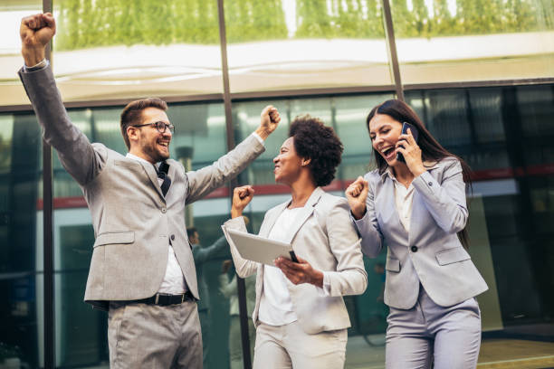 istock Business team celebrating a triumph, looking at digital tablet. 1348938532