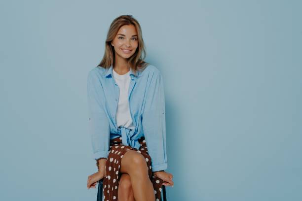 istock Good looking female with charming smile on light blue background 1348941808