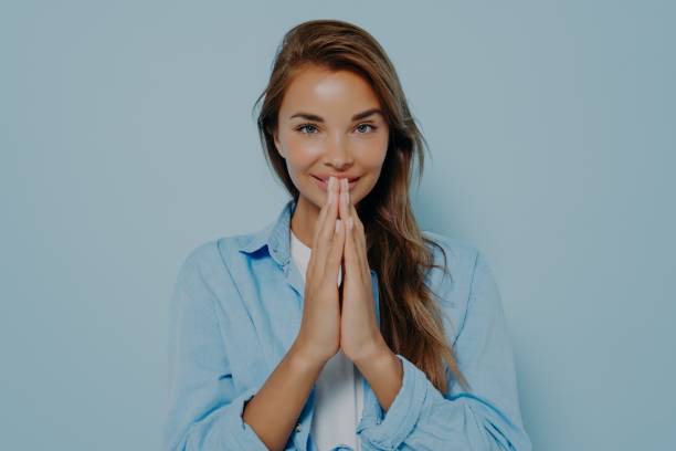 istock Happy calm grateful model female folding hands for pray Namaste gesture 1348941815