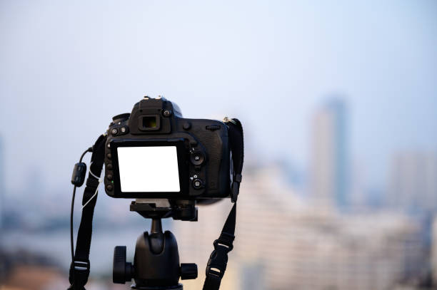 istock Digital camera put on the tripod for shoot something with white background in display or live view 1348941995