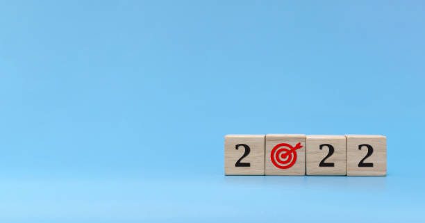 istock New year goal. number and dart board icon written on wooden cube block stack on blue background, change from 2021 to 2022, new year congratulation, countdown to 2022, goal and target plan concept 1348942609